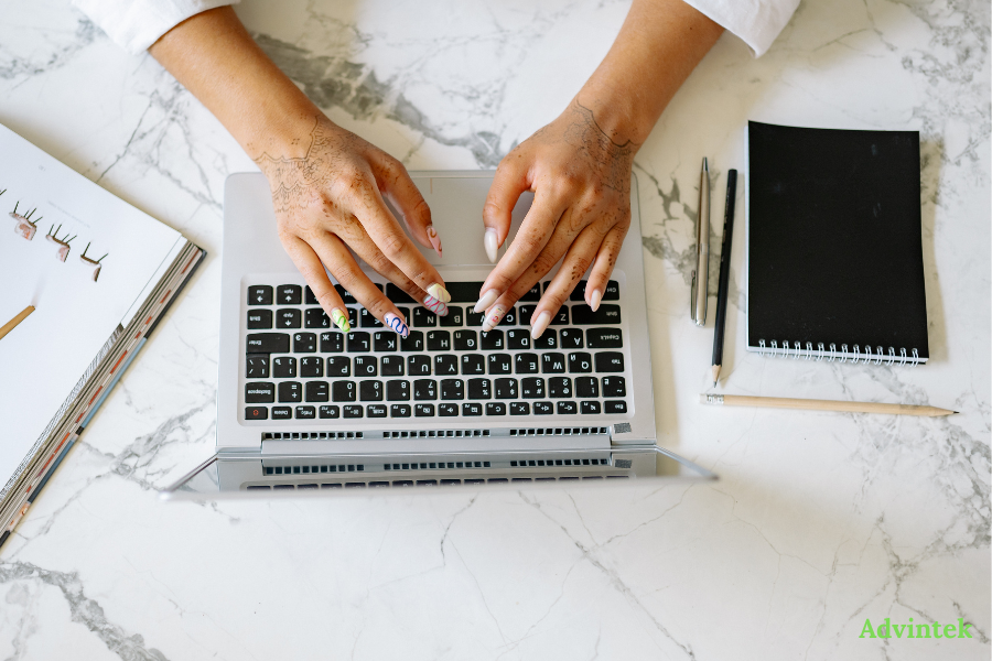 UAE E-Invoicing ERP Readiness Checklist: 15 Questions to Ask Before the ASP Deadline 3 Person typing on laptop while managing digital invoicing and finance documents