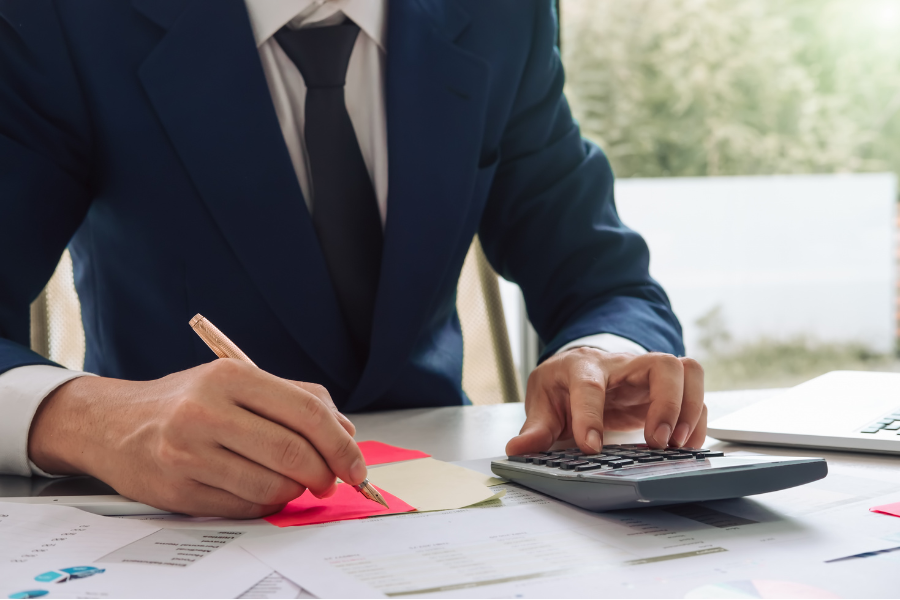 SAP E-Invoicing for UAE Without Additional DRC Costs 2 Finance professional calculating business expenses while reviewing financial documents and reports