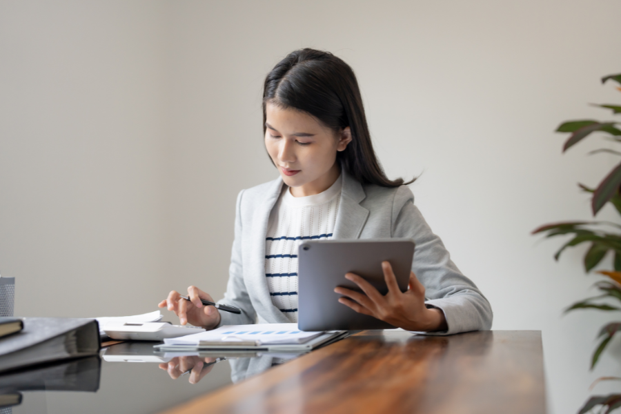 SAP E-Invoicing for UAE Without Additional DRC Costs 3 Business professional reviewing financial reports and data on a tablet at an office desk